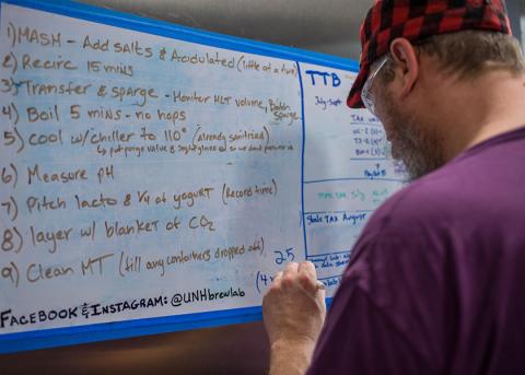 COLSA brewing lab student writing on a whiteboard